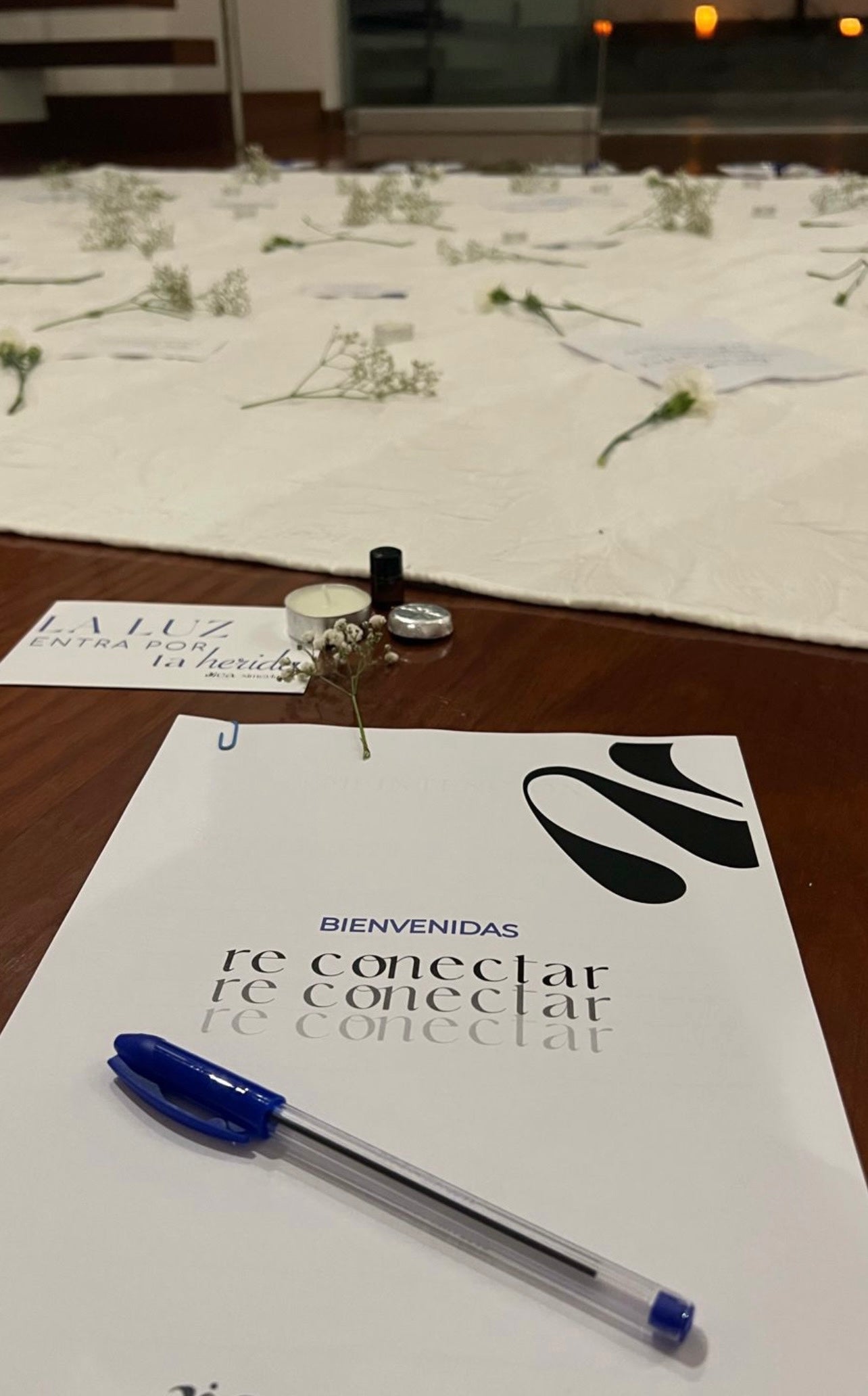 Una hoja impresa que dice "Bienvenidas Re Conectar" sobre la cual hay un lapicero. 